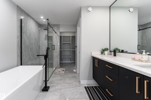 Full bath with double vanity, a marble finish shower, a freestanding tub, and a walk in closet - 5211 Kimball Crescent, Edmonton, AB - Indoor Photo Showing Bathroom