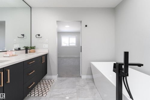 Full bath featuring vanity, a freestanding tub, and light marble finish floors - 5211 Kimball Crescent, Edmonton, AB - Indoor Photo Showing Bathroom