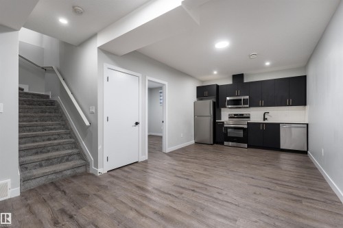 Kitchen with dark cabinets, light countertops, stainless steel appliances, recessed lighting, and dark wood-style floors - 5211 Kimball Crescent, Edmonton, AB - Indoor Photo Showing Kitchen