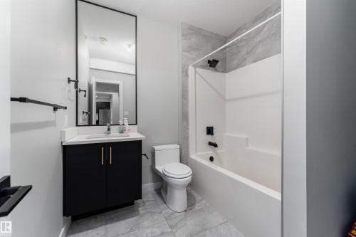 Bathroom with vanity, bathtub / shower combination, and a textured ceiling - 5211 Kimball Crescent, Edmonton, AB - Indoor Photo Showing Bathroom
