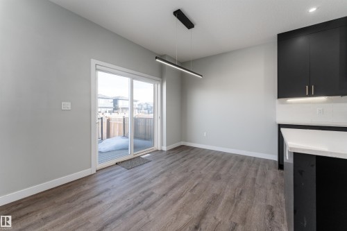 Unfurnished dining area with dark wood-style flooring and baseboards - 5211 Kimball Crescent, Edmonton, AB - Indoor Photo Showing Other Room