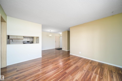 Unfurnished living room with dark wood finished floors and a textured ceiling - 213 5065 31 Avenue, Edmonton, AB - Indoor Photo Showing Other Room