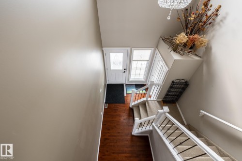 Stairs with wood finished floors, hanging lights, and a high ceiling - 11622 11 Avenue, Edmonton, AB - Indoor Photo Showing Other Room