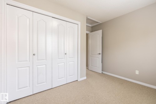 Unfurnished bedroom featuring light carpet and a closet - 11622 11 Avenue, Edmonton, AB - Indoor