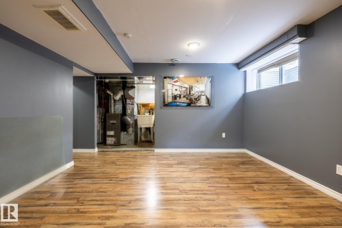 Empty room featuring light wood finished floors and heating unit - 11622 11 Avenue, Edmonton, AB - Indoor Photo Showing Other Room