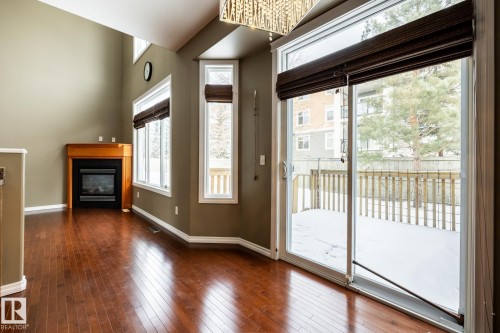Doorway to outside featuring a glass covered fireplace and hardwood / wood-style flooring - 11622 11 Avenue, Edmonton, AB - Indoor With Fireplace