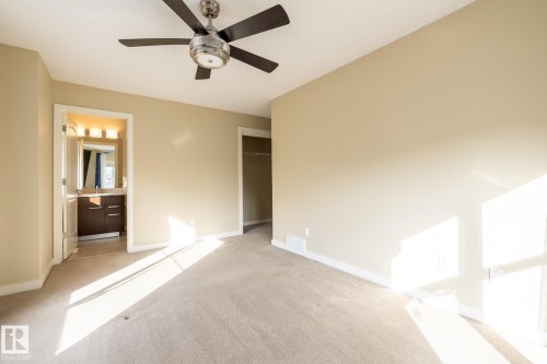 Unfurnished bedroom featuring light colored carpet, a closet, ceiling fan, and ensuite bath - 21 655 Watt Boulevard, Edmonton, AB - Indoor Photo Showing Other Room