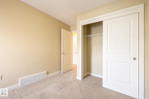 Unfurnished bedroom featuring light carpet, a closet, and a textured ceiling - 21 655 Watt Boulevard, Edmonton, AB - Indoor Photo Showing Other Room