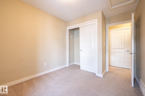Unfurnished bedroom featuring light carpet, a closet, and a textured ceiling - 21 655 Watt Boulevard, Edmonton, AB - Indoor Photo Showing Other Room