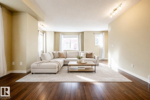 Living room with track lighting, dark wood-style floors, and a textured ceiling - 21 655 Watt Boulevard, Edmonton, AB - Indoor Photo Showing Living Room