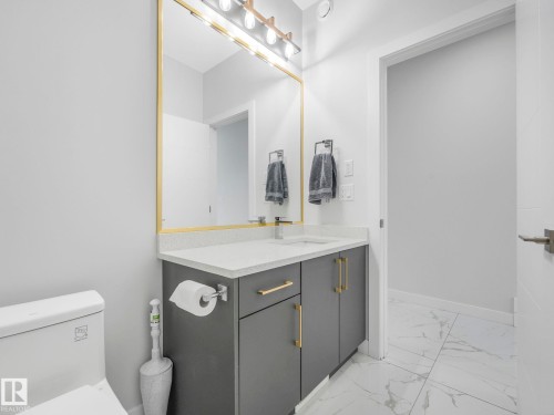 Half bath featuring vanity and light marble finish flooring - 1104 152 Avenue, Edmonton, AB - Indoor Photo Showing Bathroom