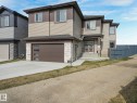 View of front of home with an attached garage, driveway, stone siding, and roof with shingles - 1104 152 Avenue, Edmonton, AB  - Outdoor 