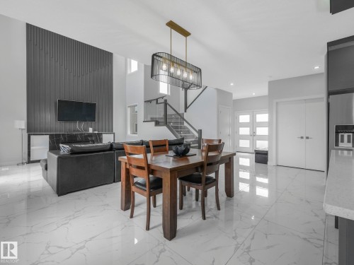 Dining area with suspended lighting and light marble finish flooring - 1104 152 Avenue, Edmonton, AB - Indoor Photo Showing Dining Room