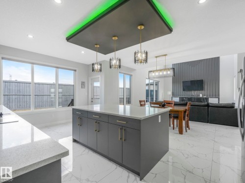 Kitchen featuring a kitchen island, open floor plan, light stone countertops, and hanging light fixtures - 1104 152 Avenue, Edmonton, AB - Indoor Photo Showing Kitchen With Upgraded Kitchen