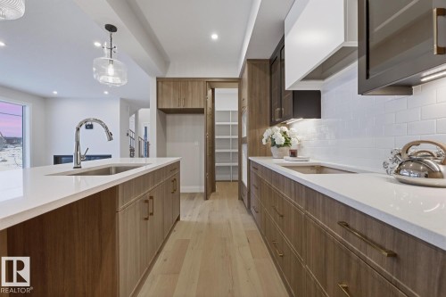 Kitchen featuring light stone countertops, light wood-type flooring, pendant lighting, modern cabinets, and recessed lighting - 6704 Crawford Way, Edmonton, AB - Indoor Photo Showing Kitchen With Upgraded Kitchen