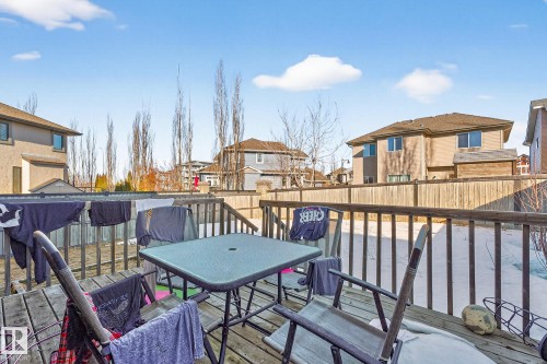 Wooden terrace featuring a residential view, outdoor dining area, and a fenced backyard - 1660 Malone Way, Edmonton, AB - Outdoor With Deck Patio Veranda With Exterior