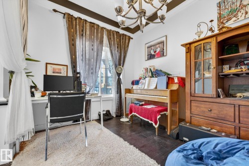 Bedroom featuring suspended lighting, a desk, dark wood-style flooring, and ornamental molding - 1660 Malone Way, Edmonton, AB - Indoor