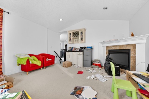 Game room featuring carpet floors, lofted ceiling, a tiled fireplace, and recessed lighting - 1660 Malone Way, Edmonton, AB - Indoor With Fireplace