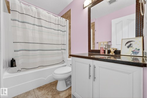 Bathroom with vanity and shower / bath combination with curtain - 1660 Malone Way, Edmonton, AB - Indoor Photo Showing Bathroom
