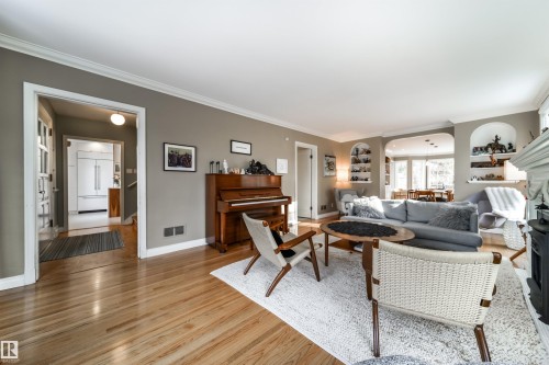 Living room with light wood finished floors, arched walkways, and crown molding - 10445 134 Street, Edmonton, AB - Indoor Photo Showing Living Room