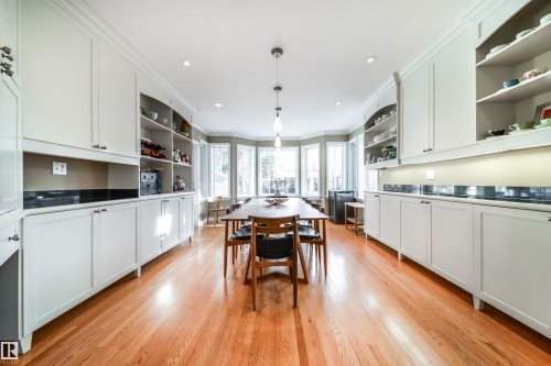 Kitchen with open shelves, ornamental molding, white cabinets, light wood finished floors, and decorative light fixtures - 10445 134 Street, Edmonton, AB - Indoor Photo Showing Kitchen