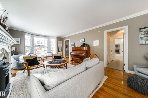 Living room featuring crown molding, wood finished floors, and a fireplace - 10445 134 Street, Edmonton, AB - Indoor Photo Showing Living Room