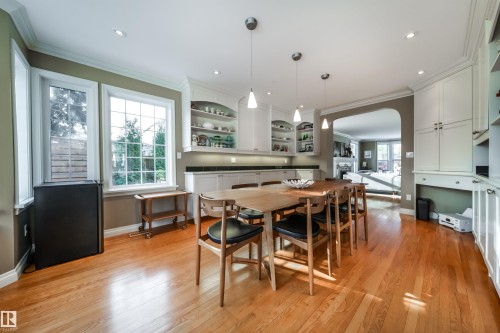 Dining area with arched walkways, ornamental molding, light wood-style flooring, a fireplace, and recessed lighting - 10445 134 Street, Edmonton, AB - Indoor Photo Showing Dining Room