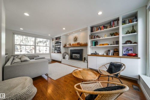 Living room with dark wood-style floors, recessed lighting, a brick fireplace, and built in shelves - 10445 134 Street, Edmonton, AB - Indoor Photo Showing Living Room With Fireplace