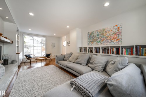 Living room with wood finished floors, recessed lighting, and a fireplace with raised hearth - 10445 134 Street, Edmonton, AB - Indoor Photo Showing Living Room With Fireplace