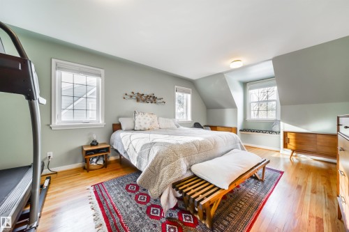 Bedroom featuring light wood-style flooring, multiple windows, and lofted ceiling - 10445 134 Street, Edmonton, AB - Indoor Photo Showing Bedroom