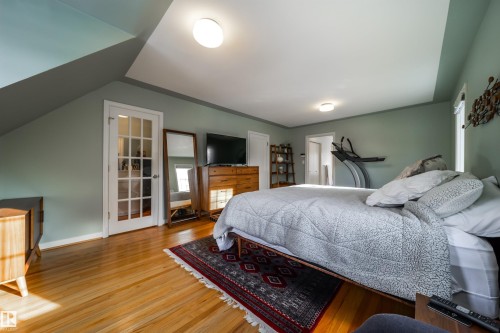 Bedroom with wood finished floors and lofted ceiling - 10445 134 Street, Edmonton, AB - Indoor Photo Showing Bedroom