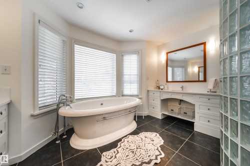 Bathroom with vanity, a soaking tub, and dark tile patterned floors - 10445 134 Street, Edmonton, AB - Indoor Photo Showing Bathroom