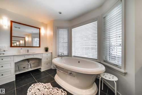 Bathroom featuring vanity, dark tile patterned flooring, and a soaking tub - 10445 134 Street, Edmonton, AB - Indoor Photo Showing Bathroom