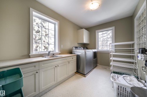 Laundry room featuring cabinet space and independent washer and dryer - 10445 134 Street, Edmonton, AB - Indoor Photo Showing Laundry Room