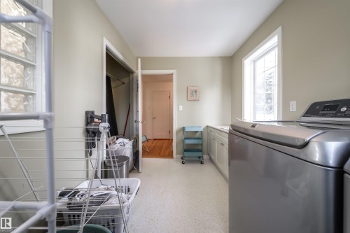 Laundry area featuring cabinet space and washing machine and dryer - 10445 134 Street, Edmonton, AB - Indoor Photo Showing Laundry Room
