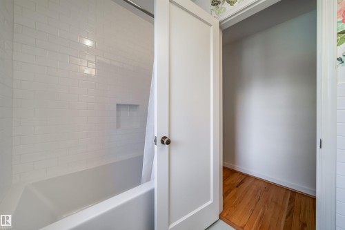 Bathroom with wood finished floors and shower / washtub combination - 10445 134 Street, Edmonton, AB - Indoor Photo Showing Other Room