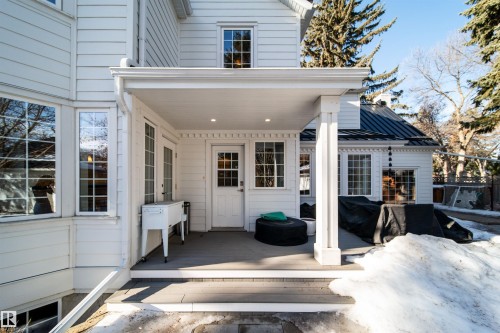 View of exterior entry featuring a wooden deck and a standing seam roof - 10445 134 Street, Edmonton, AB - Outdoor With Exterior