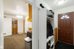 Mudroom with dark carpet and a chandelier - 