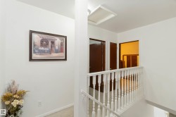 Hallway with attic access, carpet floors, and an upstairs landing - 