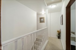 Hallway with an upstairs landing and light carpet - 