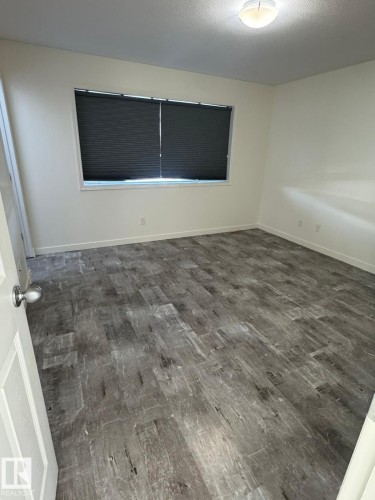 Unfurnished room featuring dark wood-style floors and a textured ceiling - 17703 65 Street, Edmonton, AB - Indoor Photo Showing Other Room