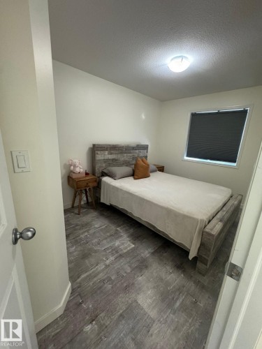 Bedroom featuring dark wood-type flooring and a textured ceiling - 17703 65 Street, Edmonton, AB - Indoor Photo Showing Bedroom