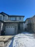 View of front facade with stone siding, covered porch, a shingled roof, and an attached garage - 17703 65 Street, Edmonton, AB  - Outdoor With Facade 