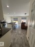 Kitchen with a kitchen bar, an island with sink, electric stove, white cabinetry, and a textured ceiling - 17703 65 Street, Edmonton, AB  - Indoor Photo Showing Other Room 
