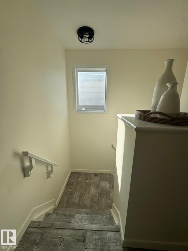 Stairway featuring baseboards and wood finished floors - 17703 65 Street, Edmonton, AB - Indoor Photo Showing Other Room