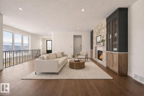 Living area with dark wood-style flooring, a textured ceiling, and a fireplace - 149 Eastgate Way, St. Albert, AB - Indoor Photo Showing Living Room With Fireplace