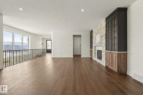 Unfurnished living room featuring dark wood-type flooring, a fireplace, a textured ceiling, and recessed lighting - 149 Eastgate Way, St. Albert, AB - Indoor With Fireplace