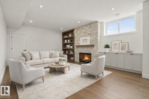 Living room with light wood-style floors, a stone fireplace, built in shelves, a textured ceiling, and recessed lighting - 149 Eastgate Way, St. Albert, AB - Indoor Photo Showing Living Room With Fireplace