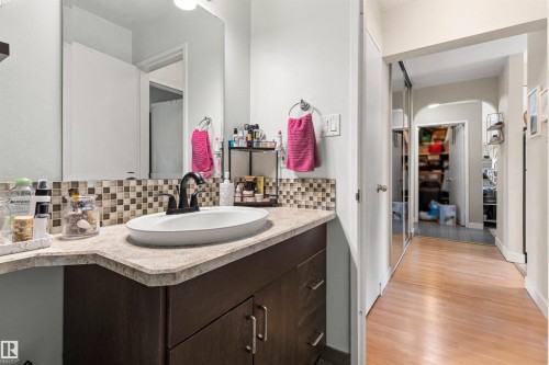 Half bath featuring vanity, tasteful backsplash, and light wood finished floors - 304 11420 40 Avenue Nw, Edmonton, AB - Indoor Photo Showing Bathroom