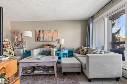 Carpeted living area featuring a textured ceiling - 304 11420 40 Avenue Nw, Edmonton, AB - Indoor Photo Showing Living Room